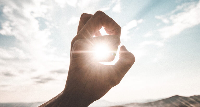 Sun peaking through the holes made the fingers of a hand