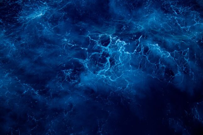 Captivating aerial view of deep blue ocean waves, showcasing nature's dynamic patterns and vibrant colors.