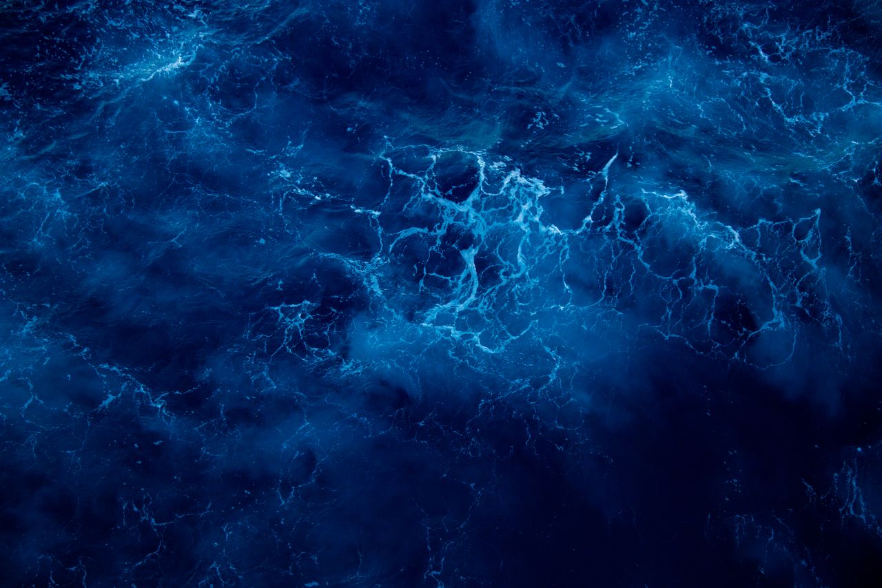 Captivating aerial view of deep blue ocean waves, showcasing nature's dynamic patterns and vibrant colors.
